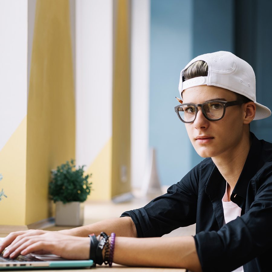 student-posing-with-laptop-classroom